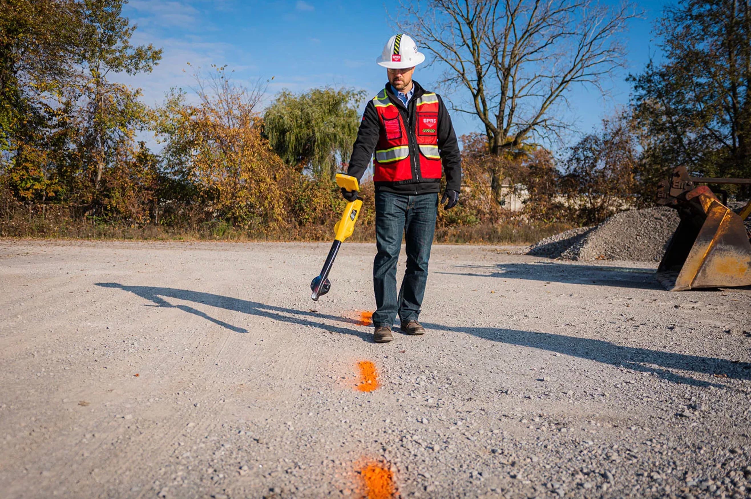 Utility locating technician using survey equipment in the field